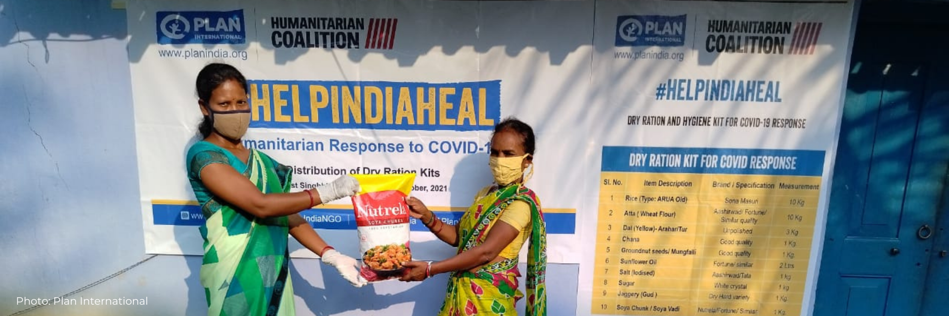 Deux femmes présentent le sac de nourriture offert aux survivants de la COVID-19 en Inde