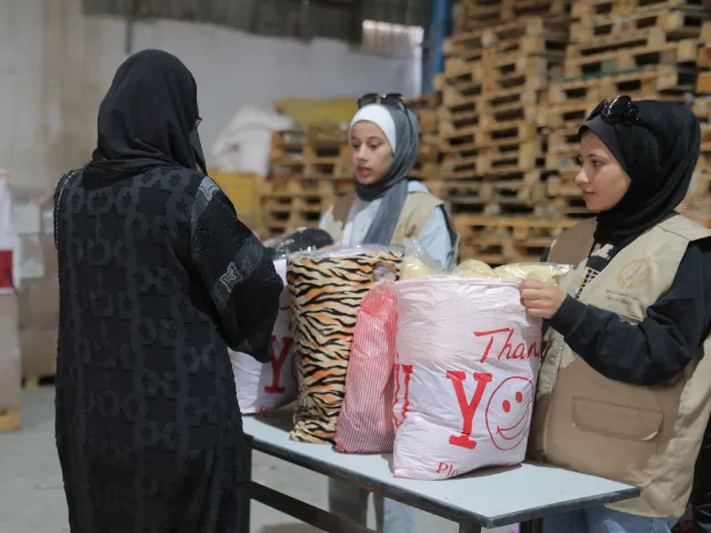 Une femme reçoit un sac de vêtements à Gaza.