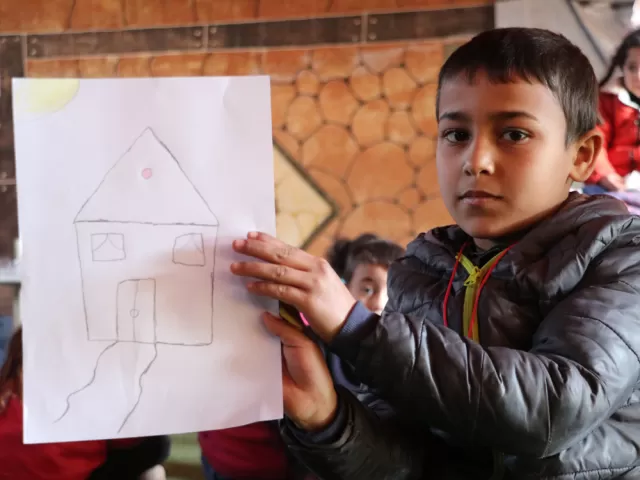 Basel, 6 years old, holding a drawing of his house