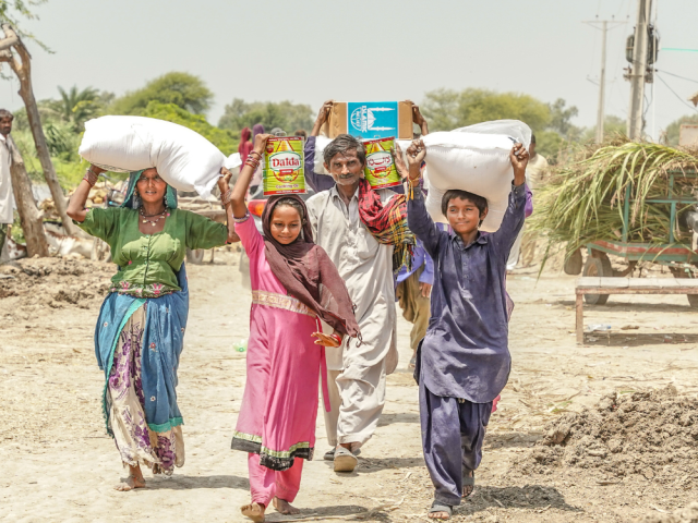 Une famille reçoit des denrées au Pakistan