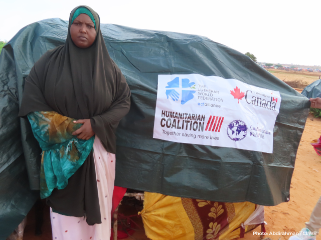 Hadija in front of her new shelter