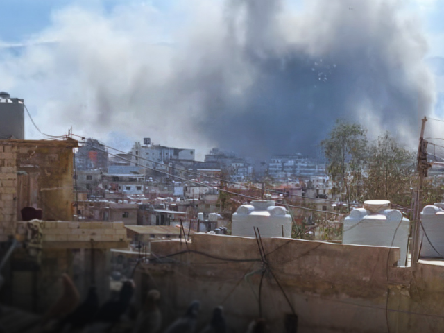 Un garçon, debout sur un toit, observe la fumée qui s'élève suite à une explosion à Beyrouth, au Liban