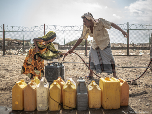 Man and child collect water in Yemen