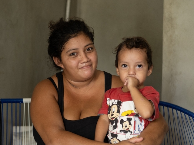 Une jeune mère avec son enfant après qu'un ouragan ait détruit leur maison