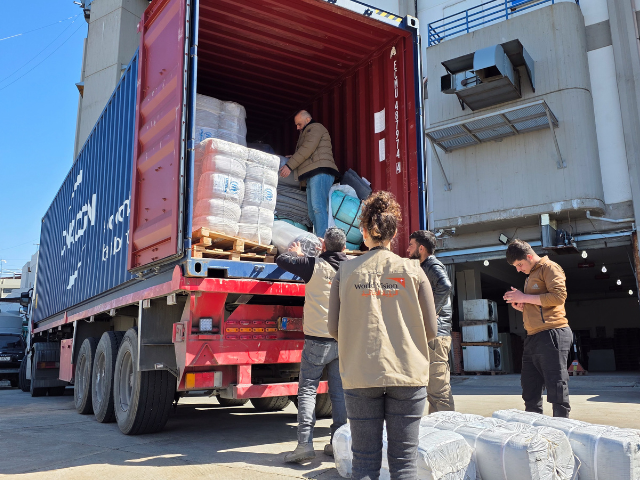 Des travailleurs humanitaires déchargent des provisions d'aide humanitaire d'un camion au Liban