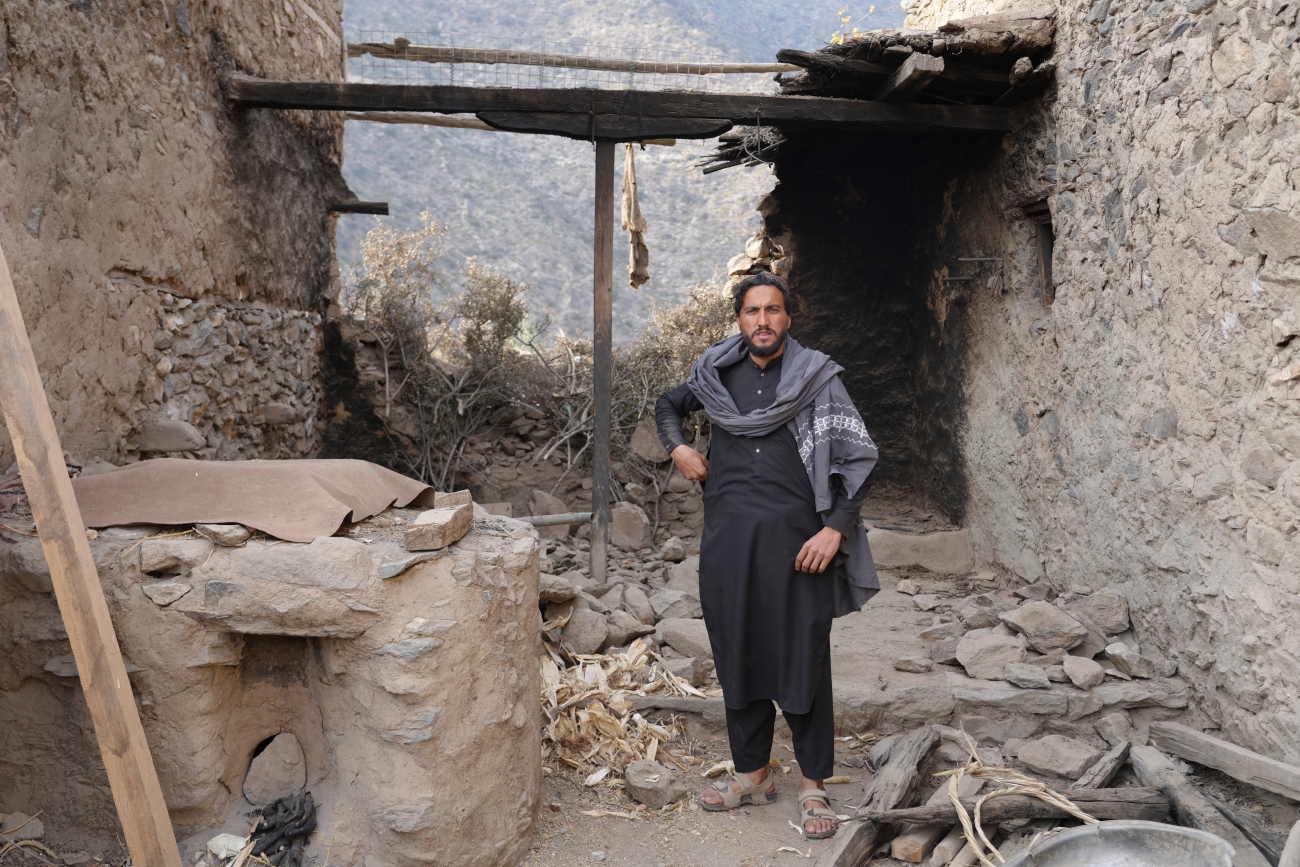 Hafizullah standing in front of his damaged house after the earthquake.